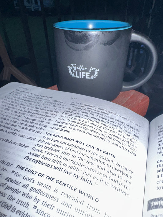 Open Bible beside a Together for Life coffee mug